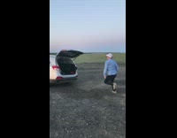 Man runs inside open hatchback trunk and closes hatch trunk on his face