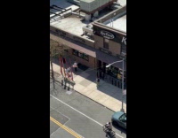 Man with blowup doll poses on sidewalk