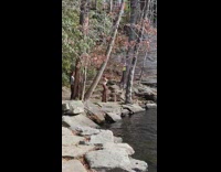 Woman in white top and brown pants near the river