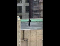 Man doing a video shoot for a music video on top of building