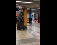 Collab winy - Man walks around station wearing bushman costume