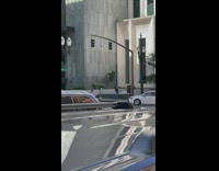 Woman in black and white dress poses on the sidewalk