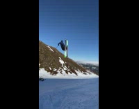 Guy double backflip green skis snow mountain 