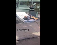 Man sleep on mattress on street camera