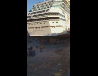 People walk off white cruise ship boat