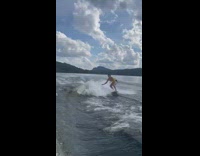 Guy almost falls off on wakeboard after spinning on lake 