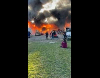 Old barn covered in large flames that produces black smoke