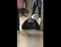 Man black jacket crawl train station floor