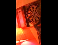 Person throws three darts misses hand dartboard