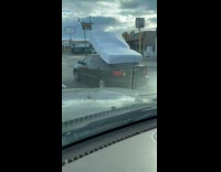 Car drive with mattress tied on roof