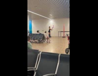 Woman swings poi balls inside the airport