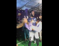 Guy bicep curls woman in purple clothes