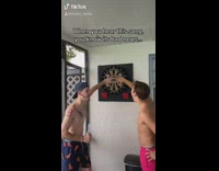 Two guys hand on dartboard green dart