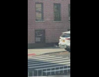 Policeman wearing tactical gear runs across street with shield