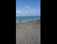 Man white blue polo sunglasses spread arms beach