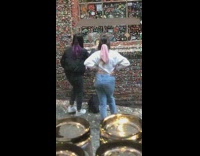 Girls prop phone up on gum wall 