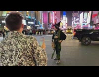 Guy in witch outfit takes poses in street. Ride your broom part 2