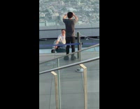 Guy striped shirt sit transparent rooftop skyscraper