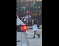 Man talks with person in Elmo head