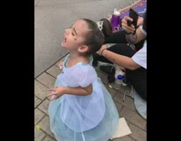 Little girl in Cinderella costume screams in excitement when she sees Cinderella at Disneyland parade