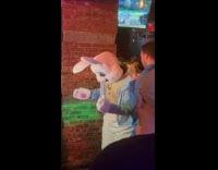 Easter bunny mascot dances inside the bar