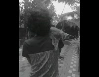 Guy rides bicycle cat on shoulder backyard 