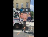 Guy carries large picture of mark zuckerberg