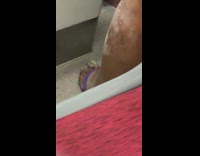 Woman purple sandals flip flops has ashy dry legs on metro train 