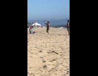 Girl black dress throw wine bottle beach