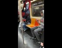 Guy in spiderman costume hanging upside down in subway train
