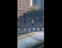 Guy balancing luggage on head rides bicycle 
