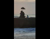 Woman play guitar statue temple beach sundown