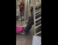 Man plays mini drums next to pink bag
