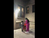 Guy lowers purple bucket down to kids in costumes