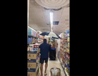 Collab WINY - Man uses umbrella inside supermarket 
