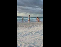Woman green bikini walk on beach windy