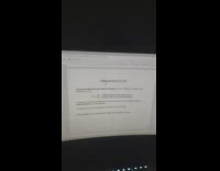 Thin spider hangs on a web in front of the laptop screen