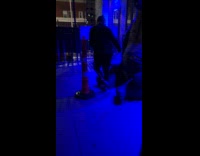 Man poses with bear statue outside bar