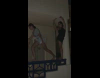 Girl stands on rail lifts foot to touch ceiling on balcony, falls off and lands on crotch