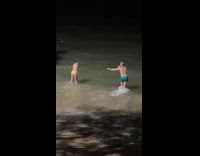 Man takes pictures of woman near boat