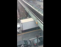 White truck gets stuck under train bridge