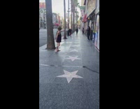 Dogs bark at shoeless woman on sidewalk 
