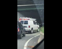 Guy rides tall unicycle under bridge 