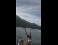 Guy orange bicycle wood ramp backflip lake 