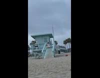 Man dances with an astronaut helmet at the lifeguard house