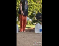 Girl throws water jug at phone backyard 