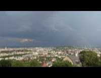 Timelapse of clouds and rainbow moving across sky