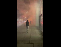 Trash on fire on sidewalk and guy trying to put out with extinguisher