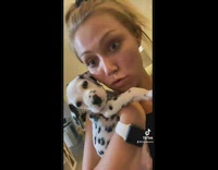 Woman in red shirt holding baby puppy dalmatian dog