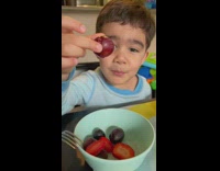 Little fan boy shows water drip on the grape